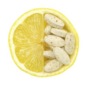 Close up of lemon and pills isolated  vitamin concept
