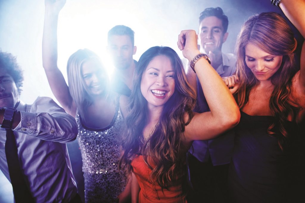 A group of young people dancing and letting loose at a nightclub